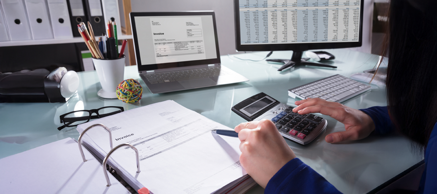 Image of a folder, laptop, calculator with spreadsheets showing