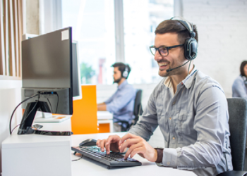 Man at laptop wearing headset